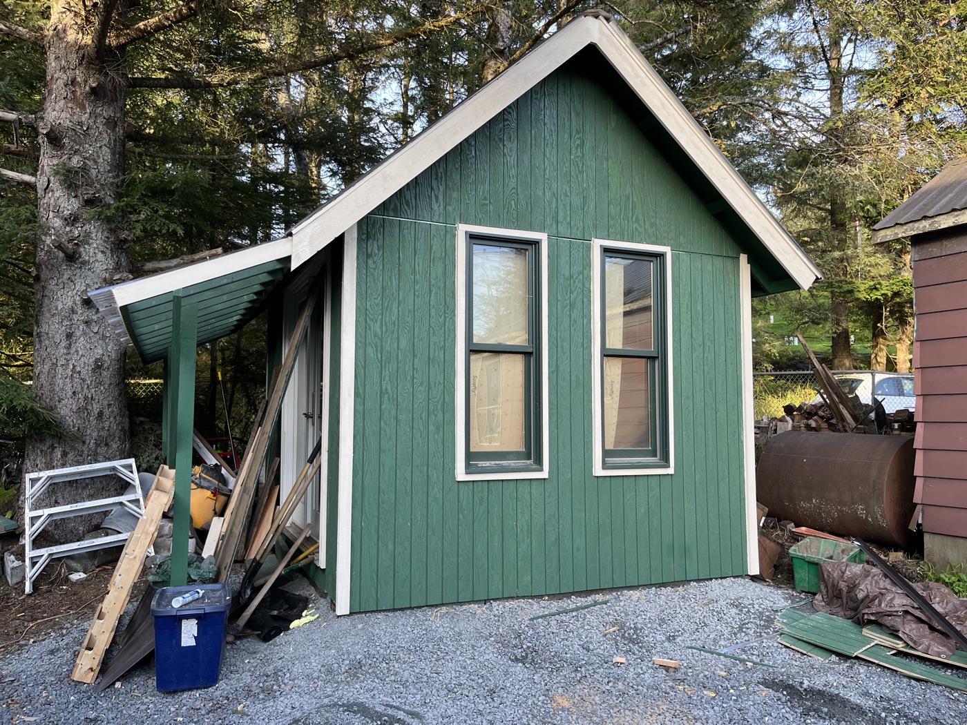 Finished outbuilding with green siding and new windows