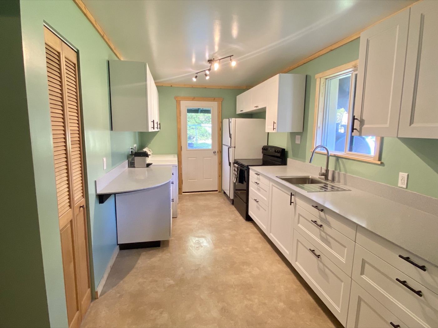 Kitchen after remodel with white cabinets and new finishes