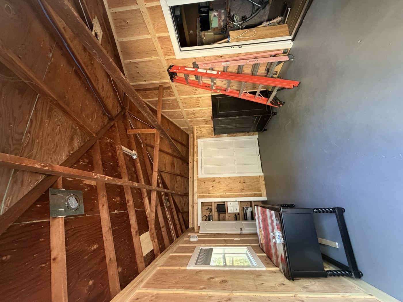 Cabin interior before renovation showing exposed framing and unfinished walls